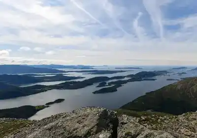 Panorama over en fjord mellem grønne fjelde